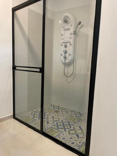Una ducha con un teléfono en una vitrina en TURULEKA Hostel, en Roldanillo