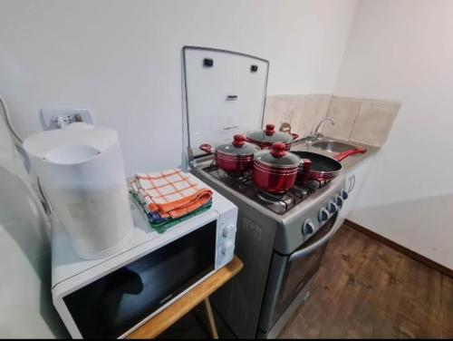 a kitchen with a stove with pots and pans on it at Mini departamento centrico in Arica