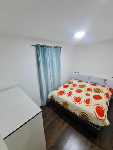 a bedroom with a bed with a comforter on it at Mini departamento centrico in Arica