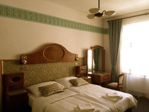 a bedroom with a large bed and a window at Hotel Kapitán in Žatec