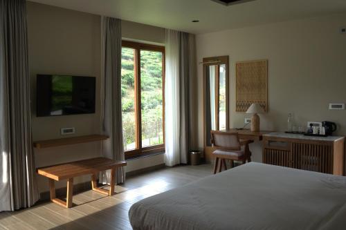 a hotel room with a bed and a desk and a desk at Red River Retreat in Hatikhuli