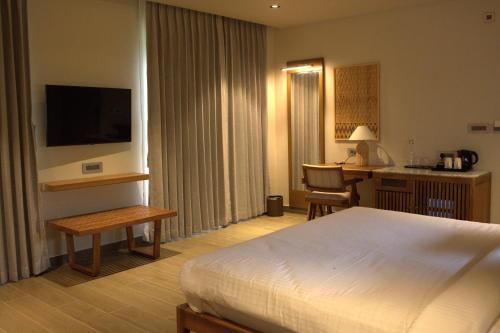 a hotel room with a bed and a desk and a kitchen at Red River Retreat in Hatikhuli