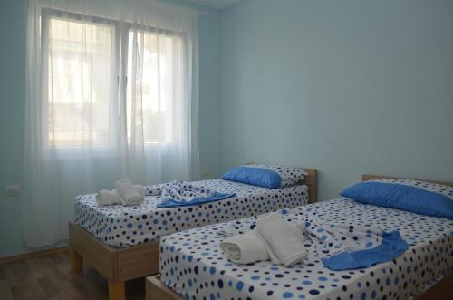 two beds in a bedroom with blue and white sheets at Rezidenca Kalter Durres in Golem
