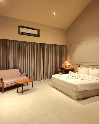 a hotel room with a bed and a couch at Red River Retreat in Hatikhuli