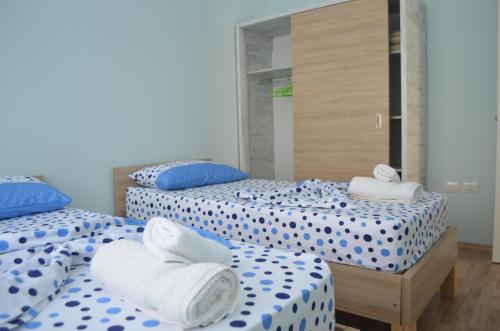 a room with two beds with blue and white sheets at Rezidenca Kalter Durres in Golem