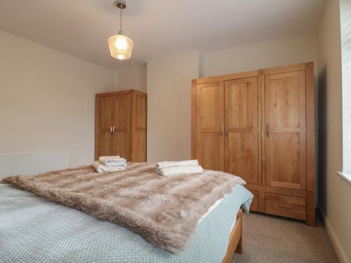 a bedroom with a large bed and a wooden cabinet at Alexandra Retreat in Skegby