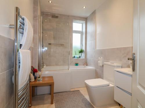 a bathroom with a tub and a toilet and a sink at Alexandra Retreat in Skegby
