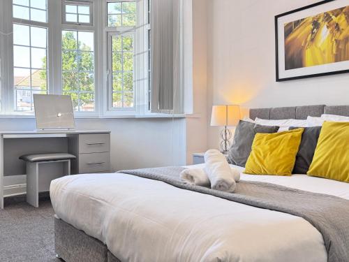 a bedroom with a bed and a desk with a laptop at OX London Heathrow stay - 1 BUS to HEATHROW in New Bedfont