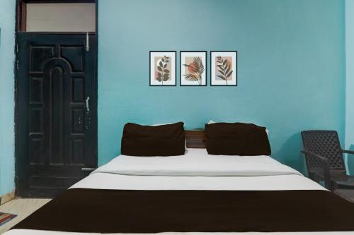 a bed in a room with a blue wall at Hotel O Shivam International in Utrāhtia