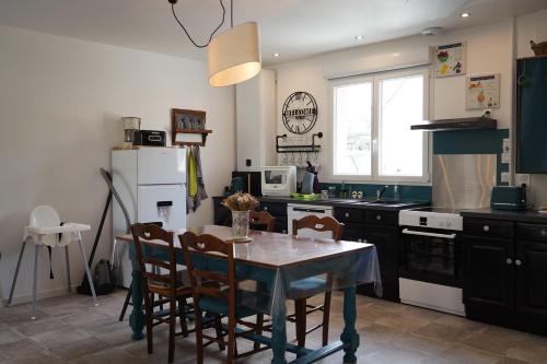 a kitchen with a table and chairs in a kitchen at Émeraude baie Mont Saint Michel in Marcey-les-Grèves