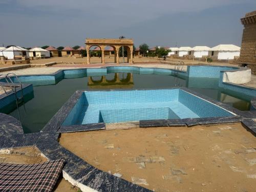 a swimming pool in the middle of a desert at Desert offbit luxurious camp in Jaisalmer