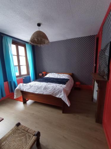 a bedroom with a bed with blue walls and a window at maison au charme rétro, équipée et tranquille in Abbeville