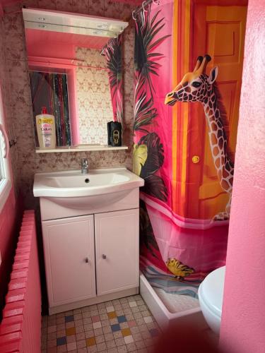 a bathroom with a sink and a giraffe on the wall at maison au charme rétro, équipée et tranquille in Abbeville