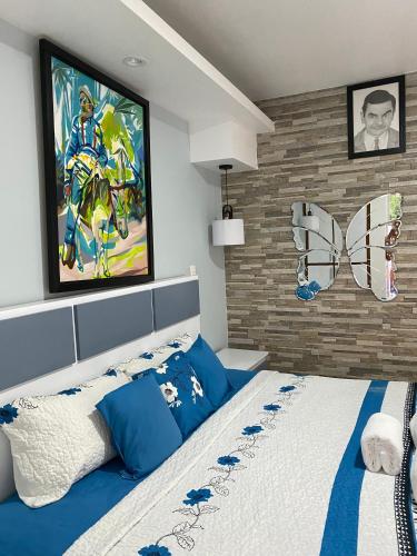 a bedroom with a king sized bed with a painting on the wall at Suite Terraza Verde Inoa in Inoa