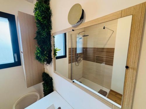 a bathroom with a shower with a glass door at Echappée Bel' cosy studio Baie de Somme in Bellancourt