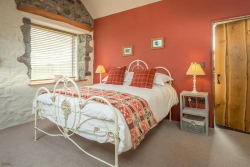 a bedroom with a white bed and orange walls at Gadlas-Sarn in Sarn