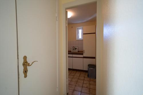 a kitchen with a door open to a kitchen with a sink at Haus Sonnenwinkel Bungalow 1 in Dahme
