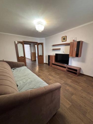 a living room with a couch and a flat screen tv at Ермекова in Karagandy