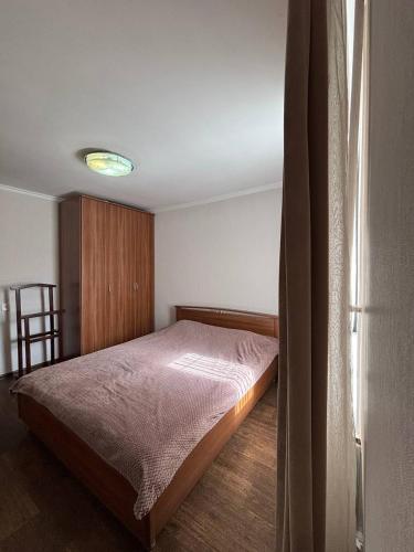 een slaapkamer met een bed en een koelkast bij Ермекова in Karagandy