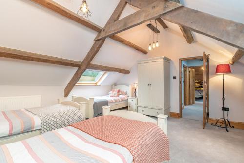 a attic bedroom with two beds and a window at Ysgubor-Sarn in Sarn