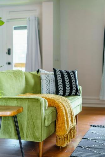 a green couch with pillows on it in a living room at Prime Location Top Rated Clean Parking Free! in Columbus