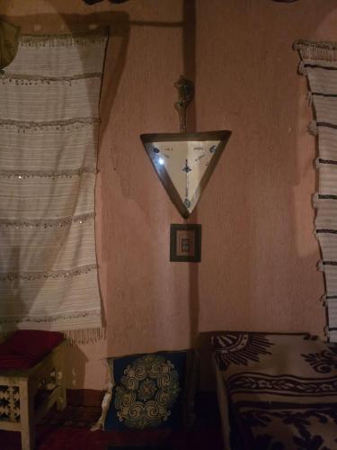 a room with a clock on the wall and a window at Maison d'hôtes tilleli in Tamnougalt