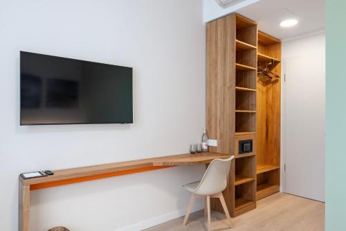 a room with a desk and a tv on a wall at Hotel Columbia in Berlin