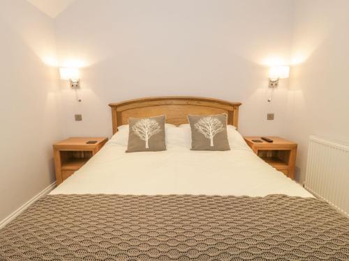 een slaapkamer met een groot bed met twee nachtkastjes bij Riverside Cottage in Conwy