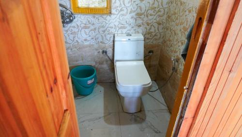 a small bathroom with a toilet and a bucket at Himalayan Homestay Gadagusain in Jibhi