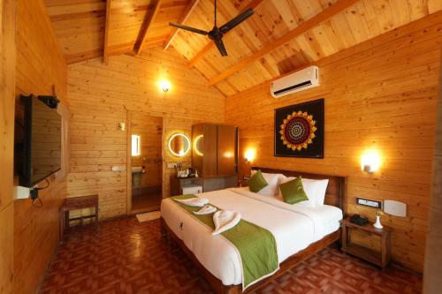 a bedroom with a large bed in a wooden room at Adhvasaha Beach Spa Resort in Port Blair