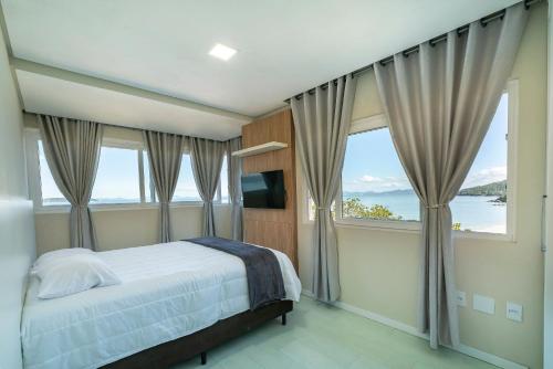 ジンブロスにあるB300 - Casa Beira Mar com piscina Privativaのベッドと大きな窓のある寝室