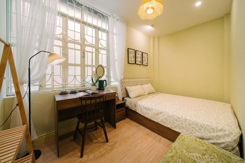 une chambre avec un lit et un bureau avec un bureau dans l'établissement Anchie Home Lý Nam Đế- Ha Noi Train Street- Ha Noi Old Quarter, à Hanoï
