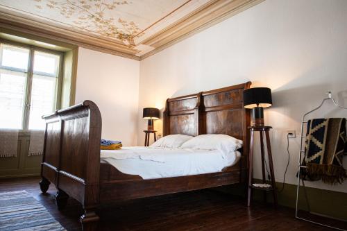 a bedroom with a large bed with a wooden headboard at Bernina Express Historic Retreat in Campocologno