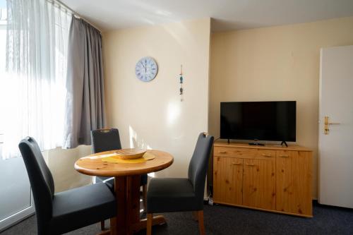 a living room with a table and a television at Haus Sonnenwinkel Bungalow 3 in Dahme