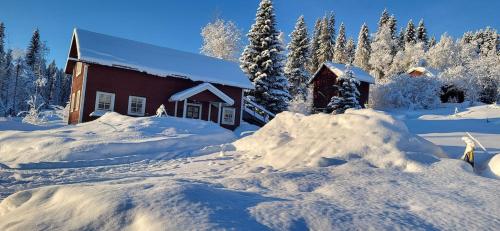 ein schneebedecktes Haus mit einem Schneehaufen in der Unterkunft Aurora Cottage Åre Järpen 