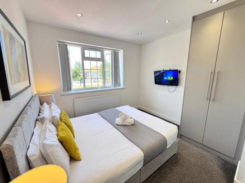 a bedroom with a large bed and a television at OX London Heathrow stay - 1 BUS to HEATHROW in New Bedfont
