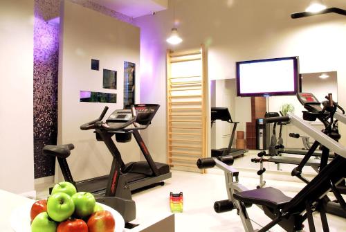 a gym with treadmills and ellipticals in a room at Hôtel Bel Ami in Paris