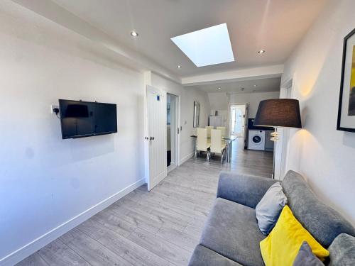 a living room with a couch and a tv on a wall at OX London Heathrow stay - 1 BUS to HEATHROW in New Bedfont