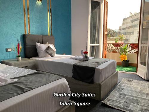 Una habitación de hotel con dos camas y balcón. en Garden City Suites Tahrir Square, en El Cairo