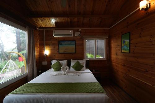 a bedroom with a bed in a wooden cabin at Adhvasaha Beach Spa Resort in Port Blair