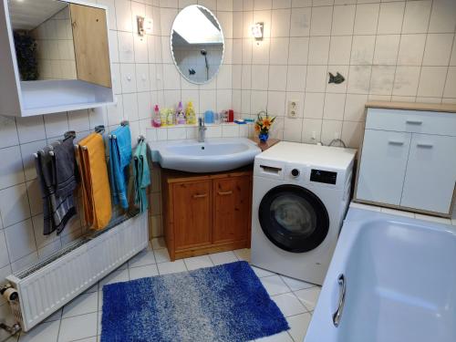 a bathroom with a washing machine and a sink at Ferienwohnung Buchner | Chiemgau Karte in Grassau