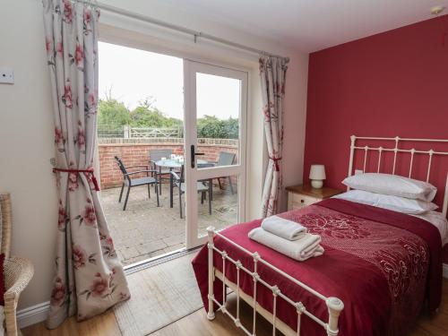 une chambre avec un lit et une porte coulissante en verre dans l'établissement Fisherman's Rest, à Henley