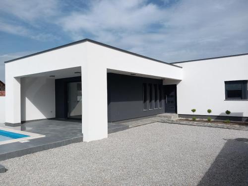 a white house with a pool in front of it at Modern villa with charm in Trnovec near Varaždin in Trnovec