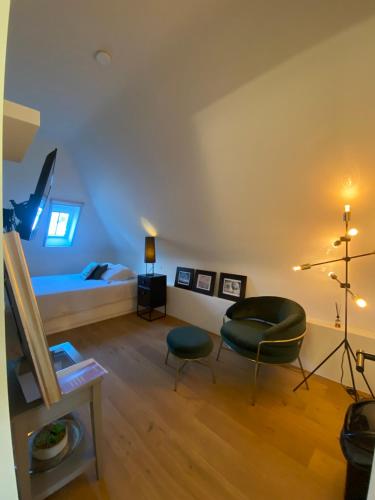 a room with a bed and two chairs and a table at Oase d'Itegem - Wellness & Luxe in Heist-op-den-Berg