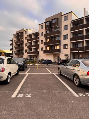a parking lot with cars parked in front of buildings at My Happy Place - Craiova in Craiova