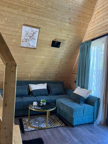 a living room with a blue couch and a table at Mestia Sunrise Cottage - 1BR Cosy Stay in Svaneti in Mestia