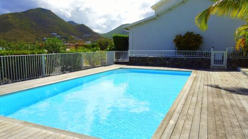 a large blue swimming pool next to a house at Relaxation 100 m from Orient Bay in Saint Martin