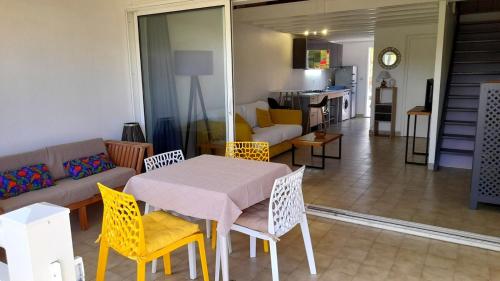 a living room with a table and chairs and a couch at Relaxation 100 m from Orient Bay in Saint Martin