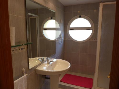 a bathroom with a sink and a mirror at Adosado Calle Mar Cantabrico in Puebla de Vallbona