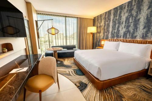 a hotel room with a bed and a chair at The REMI Scottsdale, Autograph Collection in Scottsdale